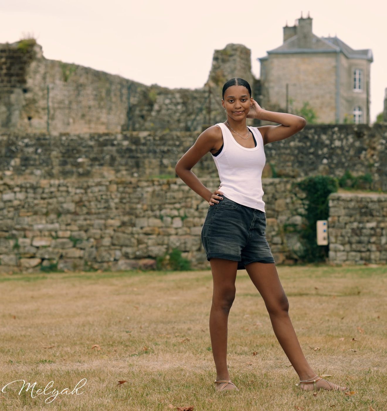 Adolescente posant devant les remparts d'un château